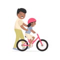 Father teaching daughter to ride bike. Caring African dad help his little child riding bicycle. Royalty Free Stock Photo